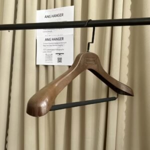Brown wood grain heavy duty plastic hanger with trouser bar and black flat hook, custom logo plate, hanging on clothing rack for wholesale apparel display