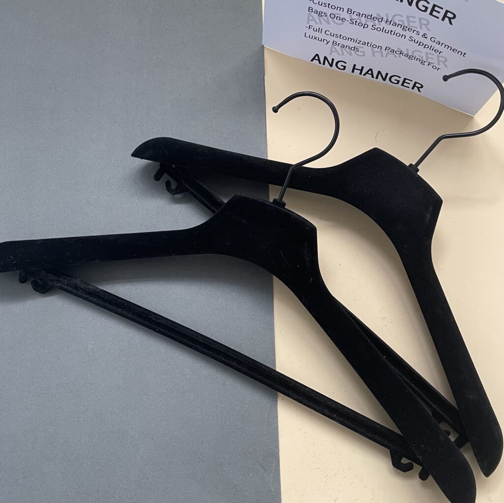 Two classic basic black velvet hangers with pant bar clips, standard non-slip flocked hangers, the most common style in black velvet hangers wholesale for clothing stores and apparel boutiques