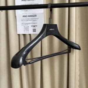 Dark wood grain bulk plastic suit hanger with non-slip trouser bar and gunmetal flat hook, custom engraved logo, hanging on clothing rack for wholesale apparel display
