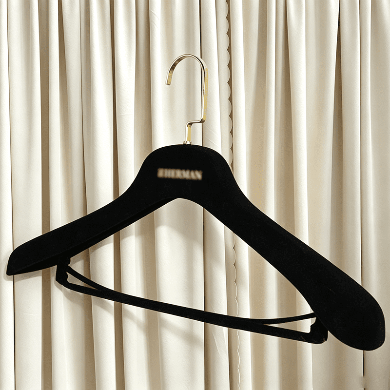Wide shoulder black velvet hanger with gold metal hook, custom brand logo and velvet pant bar, premium non-slip flocked hanger from black velvet hangers wholesale for apparel retail brands