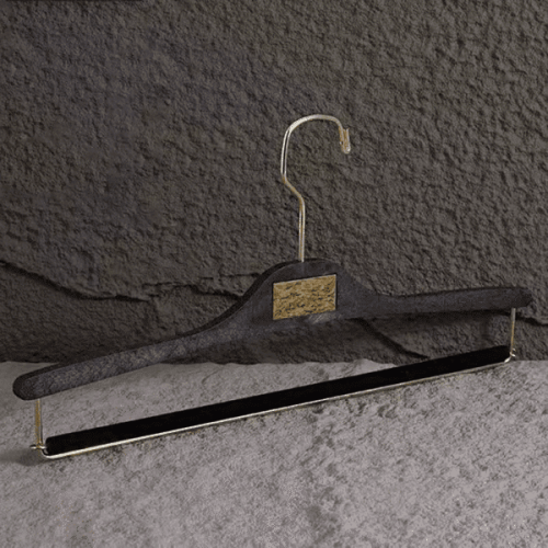 Black wood-textured plastic pants hanger with gold metal hook, non-slip velvet pant bar and custom logo plate, durable trouser hanger for denim and apparel retail display