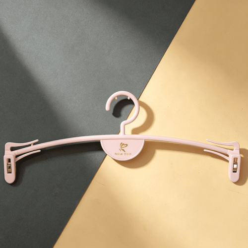 Pink plastic wholesale baby hangers with clips for kids' clothes and toddler garments