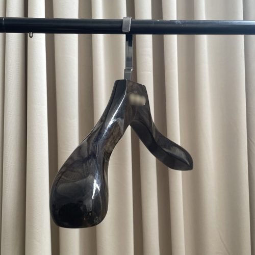 Glossy black hangers with high-gloss lacquer finish over solid wood base, extra wide shoulder design with flat metal hook, premium polished black wooden suit hangers for luxury apparel retail display